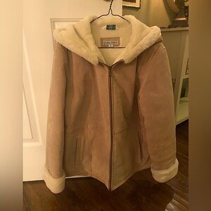 Tan suede coat with fur lining. Hood is framed by fur lining.